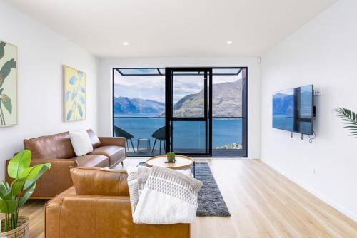 a living room with a couch and a table at Stunning Lake Veiw Property in Queenstown