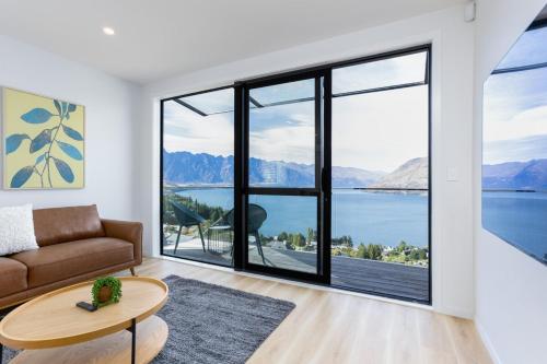a living room with a couch and a view of the water at Stunning Lake Veiw Property in Queenstown