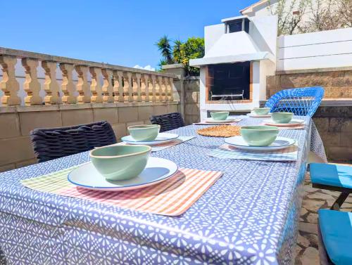 a table with bowls and plates on top of it at Casa Blava L'Escala B&Q Pool&Tennis Terrace in L'Escala