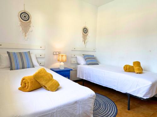 two beds with towels on them in a room at Casa Blava L'Escala B&Q Pool&Tennis Terrace in L'Escala