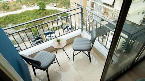 a balcony with two chairs and a table at Cozy apartment in Polisi i Vogël