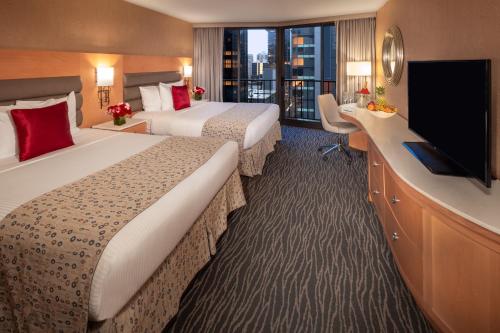a hotel room with two beds and a flat screen tv at Warwick Seattle in Seattle