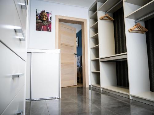 a hallway with white shelves and a door at Haus Wanderlust in Saint-Vith
