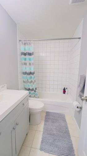 a bathroom with a toilet and a tub and a sink at Calgary Airport Stay Private Suite 1Bed in Calgary
