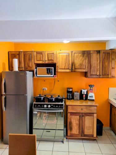 eine Küche mit Holzschränken und einem Edelstahlkühlschrank in der Unterkunft Renovated apartment in Las Palmas in Coco