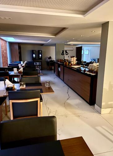 a restaurant with tables and chairs and a bar at Flat Beira Mar, Arpoar João Pessoa in João Pessoa