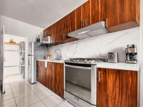 a kitchen with wooden cabinets and a stove top oven at Vallarta Luxuries in Mezcales