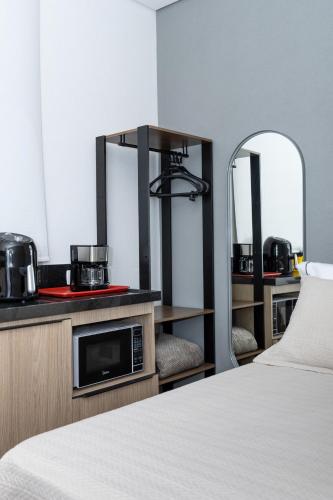 a hotel room with a bed and a mirror at Guaja 745 - Apartamento Teca in Belo Horizonte