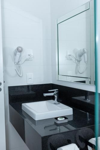 a bathroom with a sink and a mirror at Guaja 745 - Apartamento Teca in Belo Horizonte