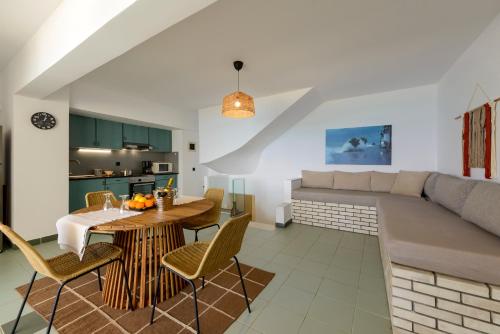 a living room with a table and a couch at Agali 2 maizonette front of the sea in Akrogiali