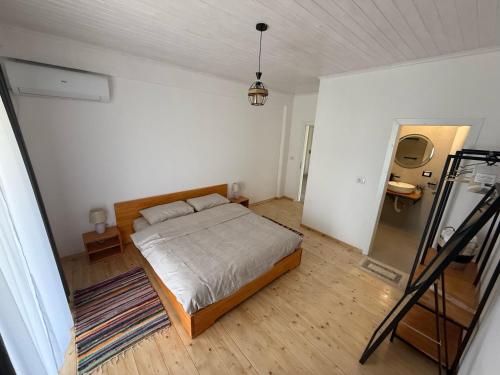 a bedroom with a bed in a white room at Shtëpia Me Lule in Përmet