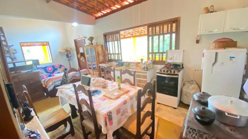 a kitchen with a table and a refrigerator at Casa Abaeté Chapada Diamantina in Mucugê