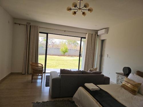 a living room with a couch and a large window at Nkandela Village in Lusaka