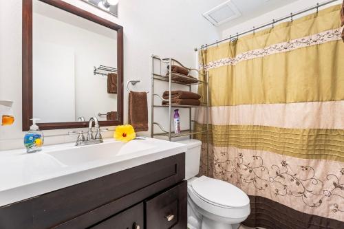 un bagno con lavandino, WC e specchio di Cozy 2br1ba AC Condo Kona Shores a Kailua-Kona