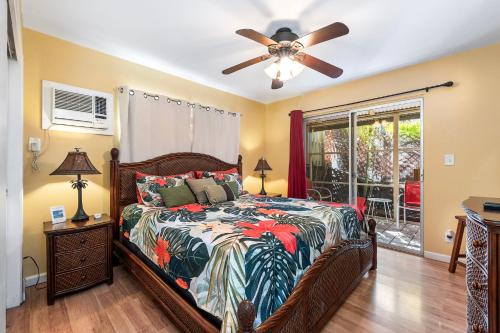 una camera da letto con un letto e un ventilatore a soffitto di Cozy 2br1ba AC Condo Kona Shores a Kailua-Kona