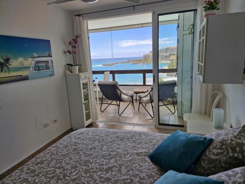 a bedroom with a bed and a view of the ocean at Patalavaca beach apartment with stunning ocean view in Patalavaca