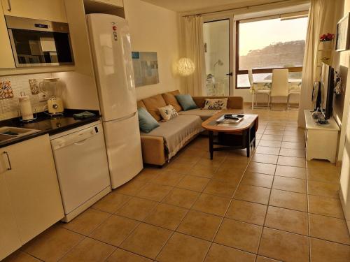 a kitchen and living room with a couch and a table at Patalavaca beach apartment with stunning ocean view in Patalavaca