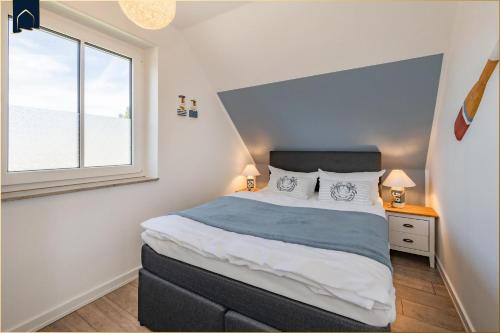 a bedroom with a large bed and a window at Waldsiedlung DHH MeerSeenSucht in Korswandt