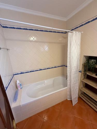a bathroom with a bath tub in a room at Breeze House Almograve - Rooms on Fishermen's Trail in Almograve