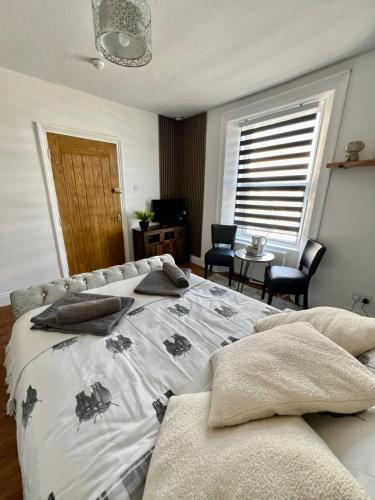 a bedroom with a bed and a table and chairs at Seaham Apartment GO69OOD Ltd in Seaham