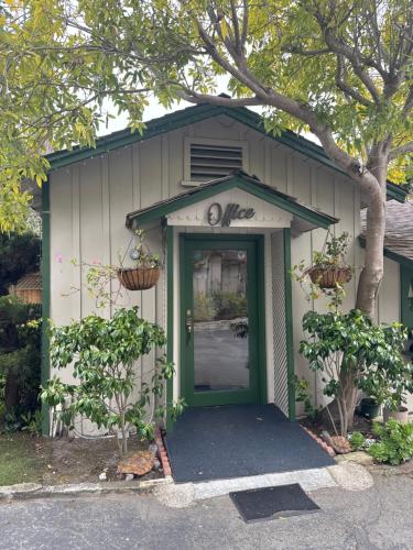 a building with a green door and a tree at Carmel Resort Inn in Carmel