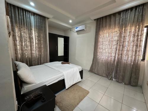 a bedroom with a bed and a large window at 2 Bedroom Service Apartment in Kaduna in Birnawa