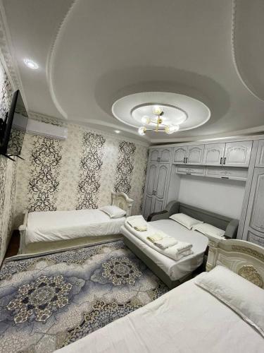 a bedroom with three beds and a ceiling at Anoras home in Samarkand