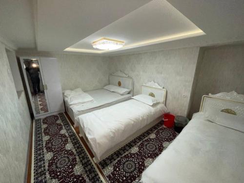 a room with two beds in a room with at Anoras home in Samarkand