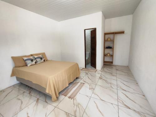 a bedroom with a bed and a marble floor at CAJUÍ da VILA in Atins