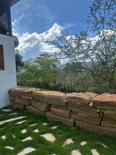 a stone retaining wall next to a house at Cabaña Capella Campestre Green in Pinchote