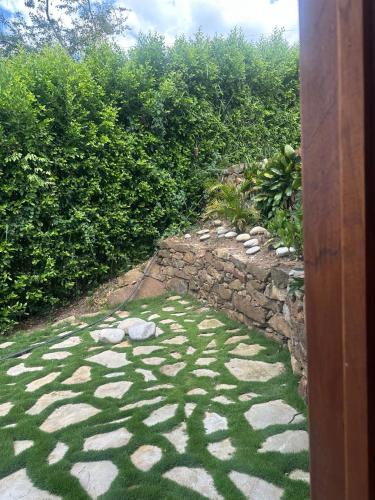 a garden with a stone path and a stone wall at Cabaña Capella Campestre Green in Pinchote