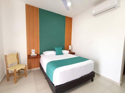 a bedroom with a large bed and a chair at Punta Colibrí in Brisas de Zicatela