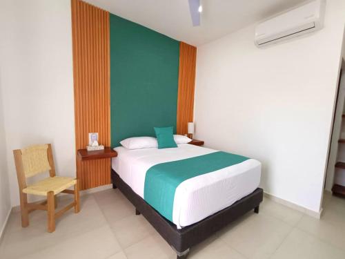 a bedroom with a bed and a chair in it at Punta Colibrí in Brisas de Zicatela