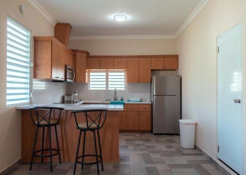 a kitchen with wooden cabinets and a stainless steel refrigerator at Master Beachfront Studios Seven Seas in Fajardo