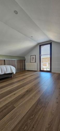une chambre vide avec un lit et du parquet dans l'établissement Appartement à proximité de Paris, à Vitry-sur-Seine