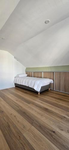 Ce lit se trouve dans un dortoir doté de parquet. dans l'établissement Appartement à proximité de Paris, à Vitry-sur-Seine