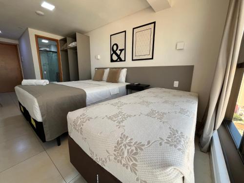 a hotel room with two beds and a window at MANAÍRA APART HOTEL in João Pessoa