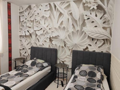 two beds in a room with a wall mural at Heni Apartman in Nagykanizsa