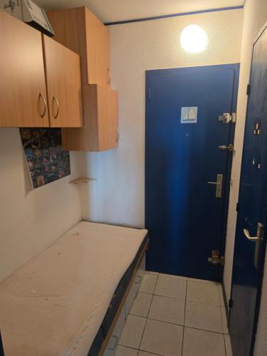 une cuisine avec une porte bleue et un comptoir dans l'établissement L'Essentiel, au Cap d'Agde