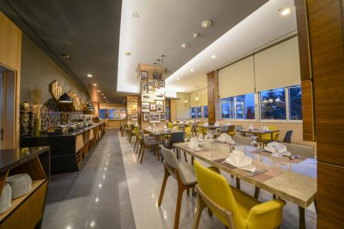 a restaurant with long tables and yellow chairs at Radisson Blu Ankara in Ankara