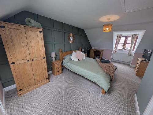 a bedroom with a bed and a wooden cabinet at Purdie Close Holiday Let in Cheddar