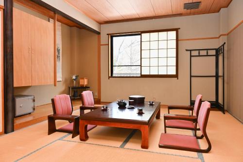 a living room with a wooden table and chairs at Komakusa Hotel in Matsumoto