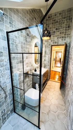 a bathroom with a sink and a toilet and a mirror at Casa Damadian in Constanţa
