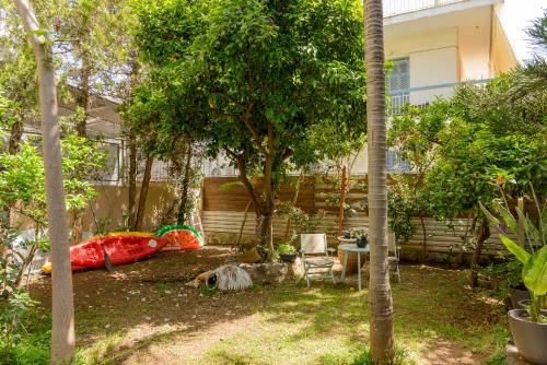 a backyard with a table and chairs and trees at Agali 1 Mesonet In Front Of The Sea in Akrogiali
