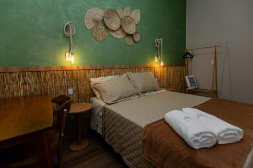 a bedroom with a bed and a desk and a table with a table at Casa Floresta - Caminhos de OP in Ouro Preto