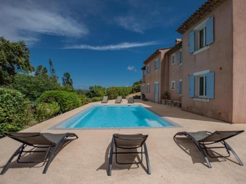 une piscine avec deux chaises et une maison dans l'établissement Plage, à Cavalaire-sur-Mer
