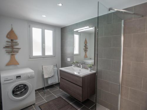 une salle de bain avec un lavabo et une machine à laver dans l'établissement Plage, à Cavalaire-sur-Mer