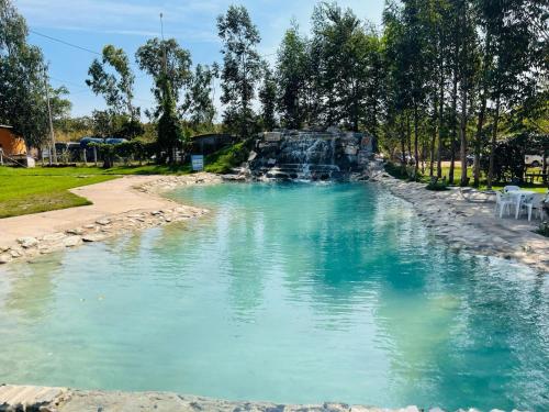 a swimming pool with a waterfall in a park at Pousada Pesque Pague Jango in Cuiabá