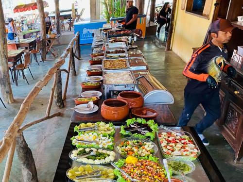 a buffet line with a long table filled with food at Pousada Pesque Pague Jango in Cuiabá