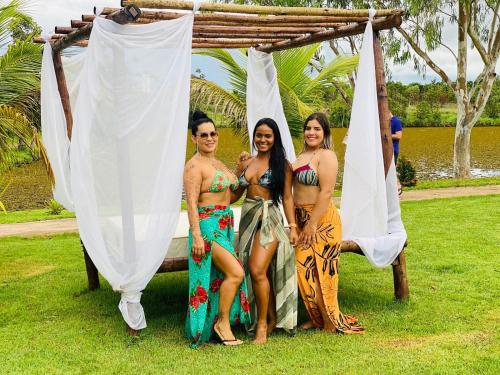 a group of three women standing under a canopy at Pousada Pesque Pague Jango in Cuiabá